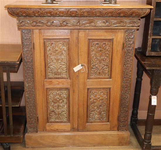 A carved oak 2-door cupboard W.104cm